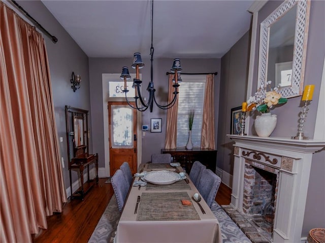 dining area with dark hardwood / wood-style flooring and an inviting chandelier