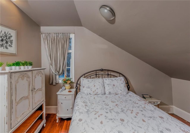 bedroom featuring vaulted ceiling and hardwood / wood-style flooring