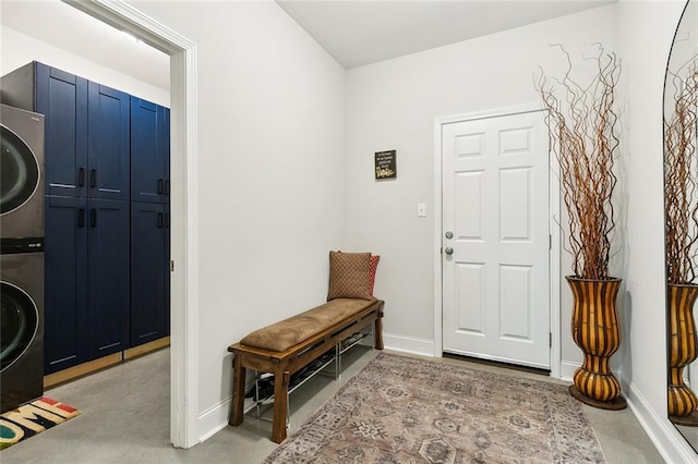 foyer featuring light carpet and stacked washer and clothes dryer