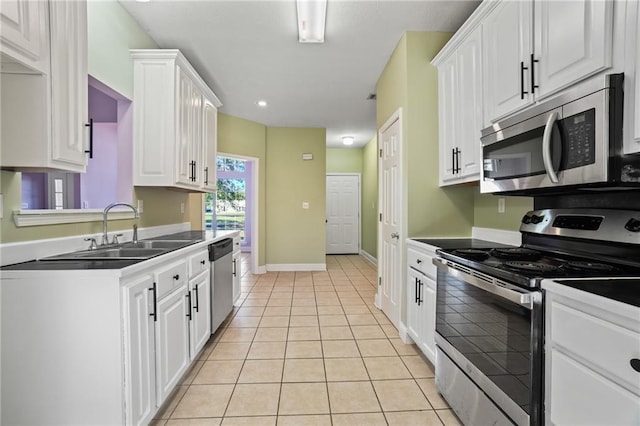 kitchen with white cabinetry, sink, light tile patterned flooring, and stainless steel appliances