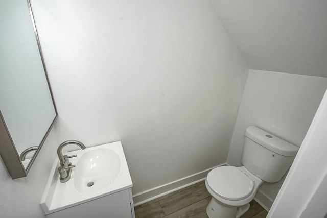 bathroom featuring wood-type flooring, vanity, and toilet