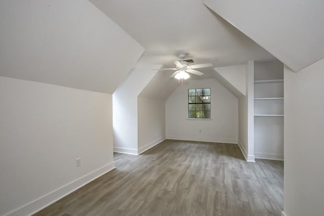 bonus room with wood-type flooring, vaulted ceiling, and ceiling fan