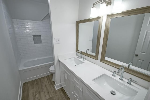 full bathroom featuring toilet, vanity, tiled shower / bath combo, and hardwood / wood-style flooring