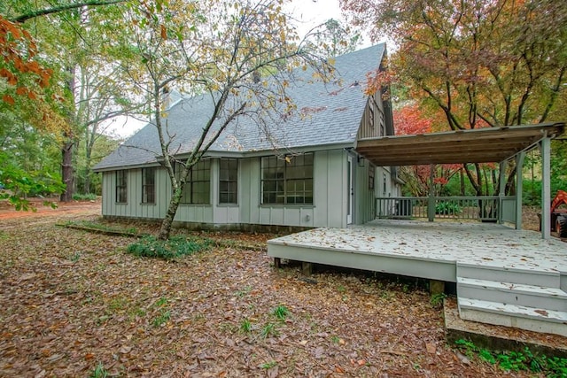 rear view of property featuring a carport and a deck