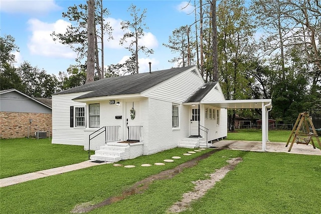 view of front of house featuring central AC unit, a front yard, and a carport