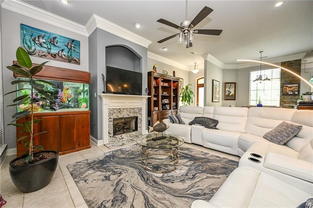 living room featuring light tile patterned floors, a fireplace, ornamental molding, and ceiling fan