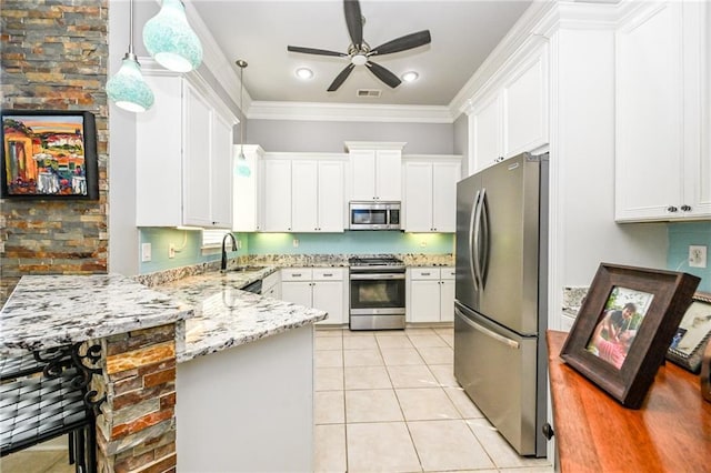 kitchen featuring crown molding, hanging light fixtures, light tile patterned floors, appliances with stainless steel finishes, and white cabinets