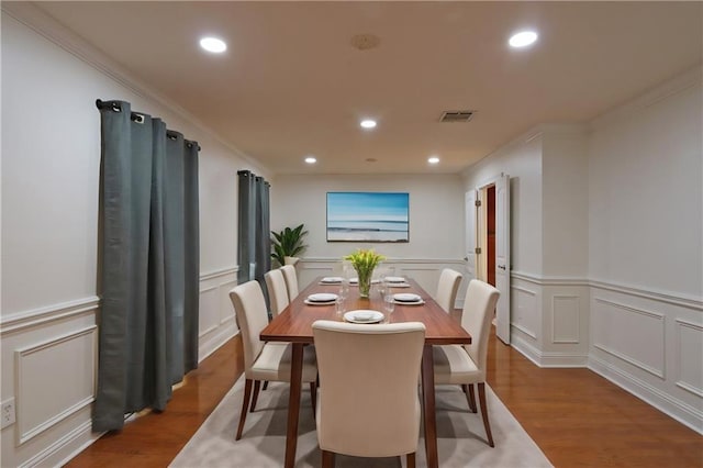 dining area featuring hardwood / wood-style flooring and crown molding