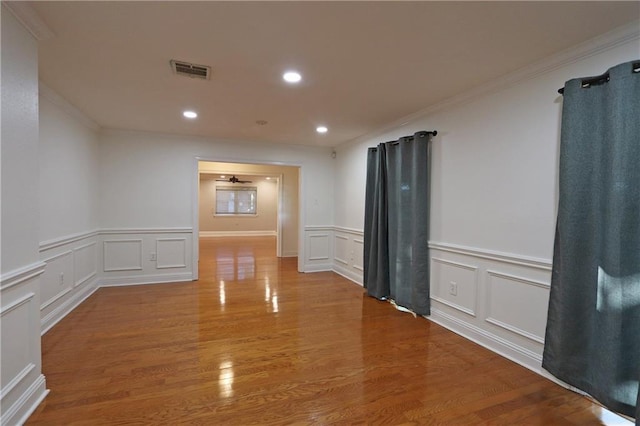 spare room with hardwood / wood-style floors, ceiling fan, and crown molding