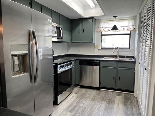 kitchen featuring appliances with stainless steel finishes, sink, and light hardwood / wood-style floors