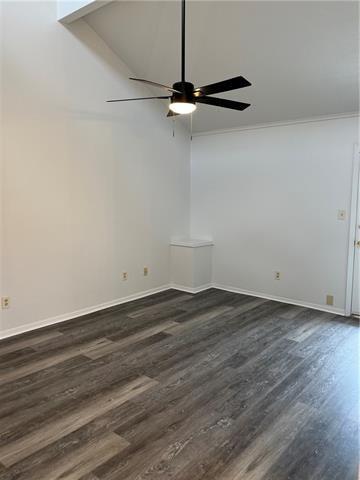 empty room featuring dark wood-type flooring, ornamental molding, and ceiling fan