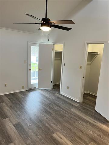 interior space with ceiling fan, access to exterior, high vaulted ceiling, dark hardwood / wood-style floors, and a spacious closet