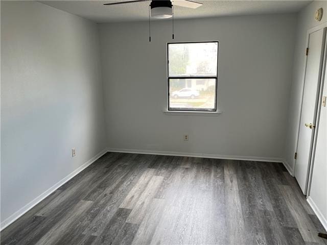 empty room featuring ceiling fan and dark hardwood / wood-style flooring