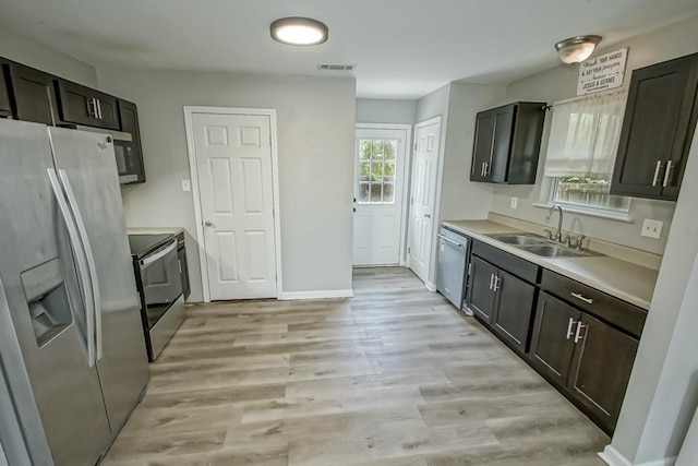 kitchen featuring dark brown cabinets, stainless steel appliances, light hardwood / wood-style flooring, and sink