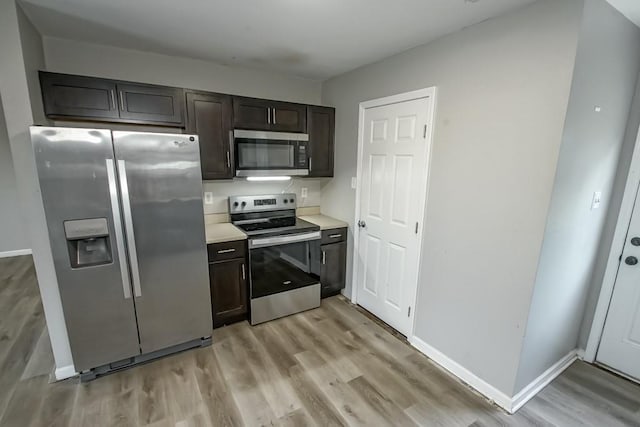 kitchen featuring light wood-type flooring, stainless steel appliances, and dark brown cabinetry