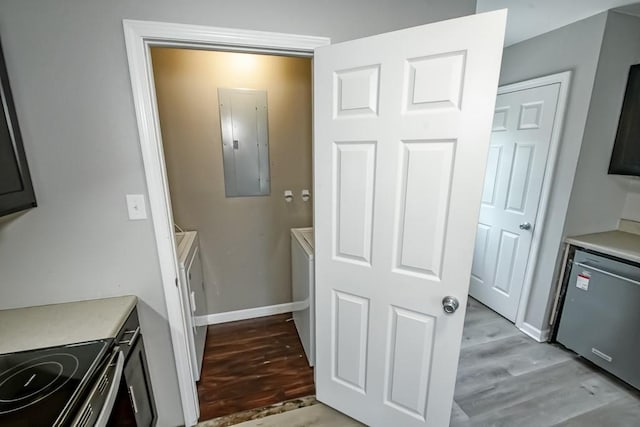 laundry room with electric panel and light hardwood / wood-style floors