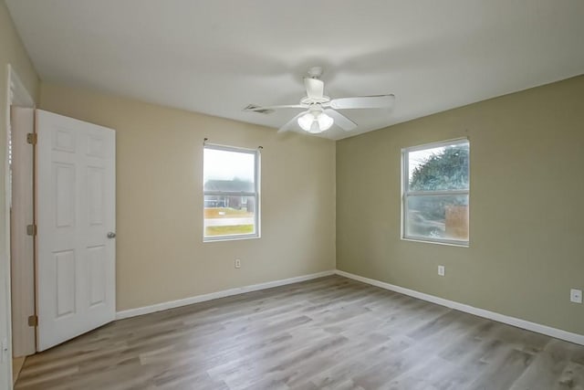 empty room featuring light hardwood / wood-style flooring, plenty of natural light, and ceiling fan