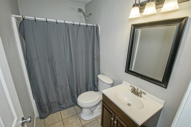 bathroom with toilet, vanity, tile patterned floors, and walk in shower