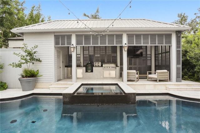 rear view of property with area for grilling, a patio, and a pool with hot tub