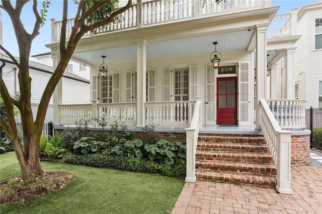 view of exterior entry with a yard and covered porch