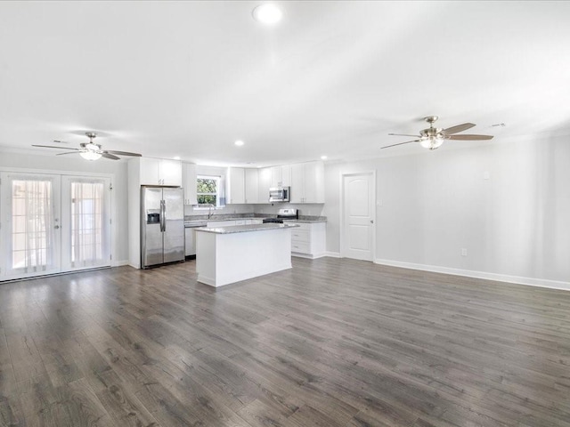 kitchen with a center island, french doors, dark wood-type flooring, white cabinets, and appliances with stainless steel finishes