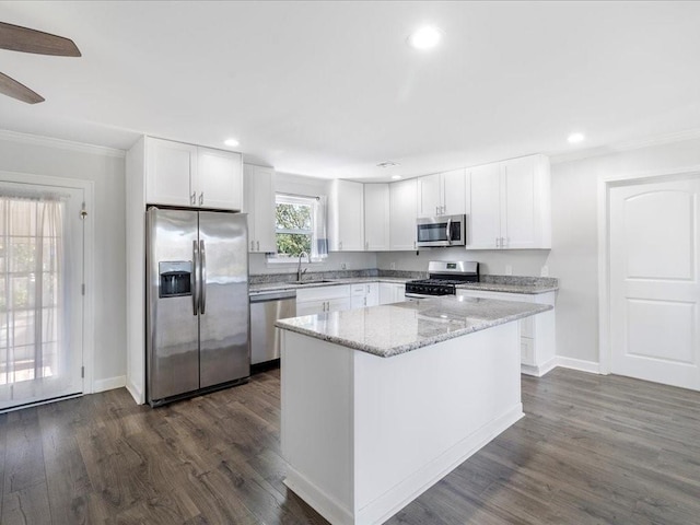 kitchen with dark hardwood / wood-style floors, a kitchen island, white cabinetry, and stainless steel appliances