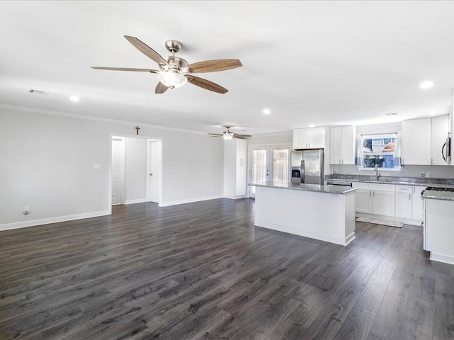 kitchen featuring dark hardwood / wood-style flooring, stainless steel appliances, sink, white cabinetry, and a kitchen island