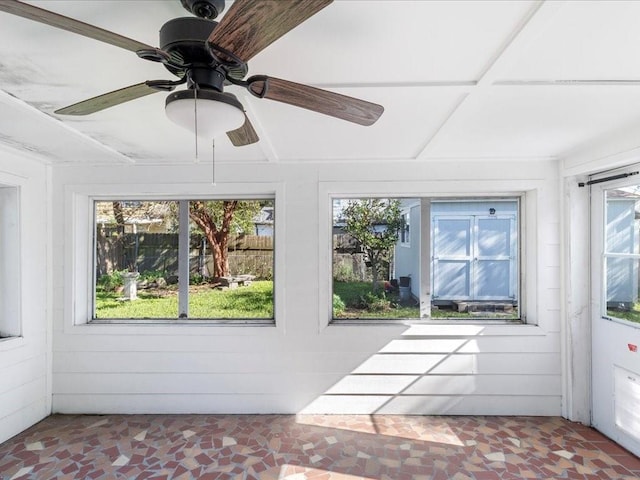 unfurnished sunroom with ceiling fan