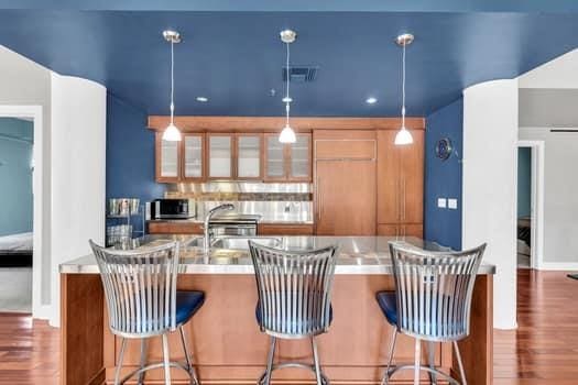 kitchen with pendant lighting, dark wood-type flooring, a kitchen breakfast bar, sink, and kitchen peninsula