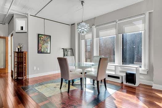 dining area with hardwood / wood-style flooring, plenty of natural light, and a notable chandelier