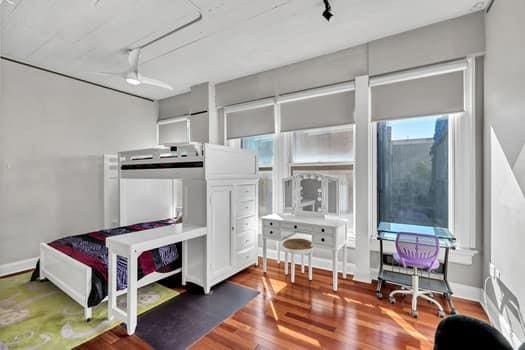 bedroom featuring hardwood / wood-style floors and track lighting