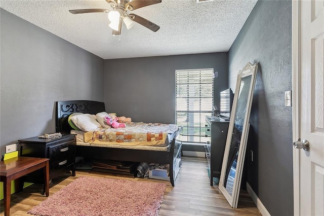 bedroom featuring a textured ceiling, light hardwood / wood-style flooring, and ceiling fan