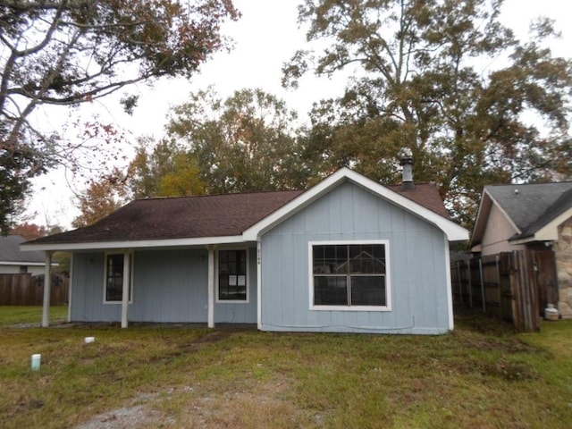 rear view of property featuring a lawn