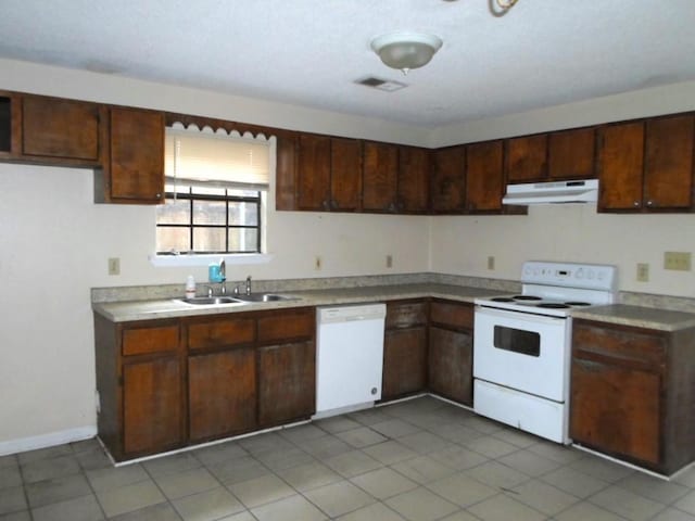 kitchen with dark brown cabinetry, white appliances, and sink