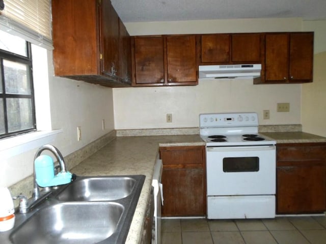 kitchen featuring dark tile patterned flooring, white range with electric stovetop, and sink