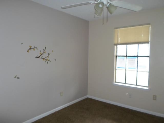 carpeted empty room featuring ceiling fan