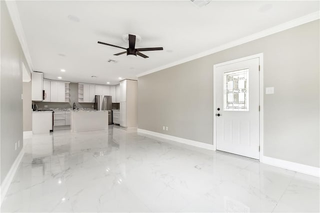 unfurnished living room with ceiling fan and crown molding