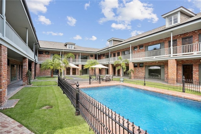 view of swimming pool featuring a yard