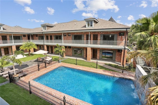 view of pool featuring a lawn and a patio