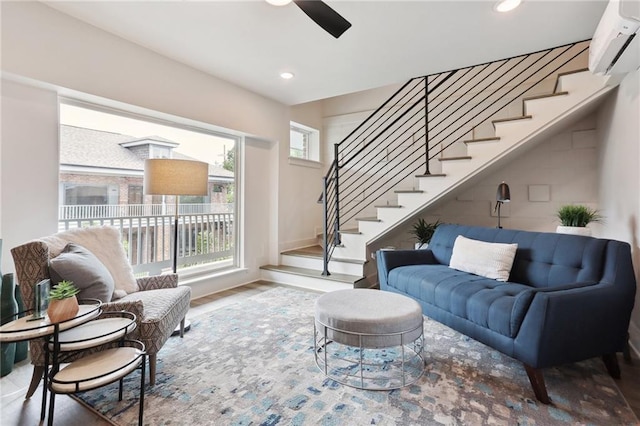 living room featuring ceiling fan, an AC wall unit, and hardwood / wood-style flooring