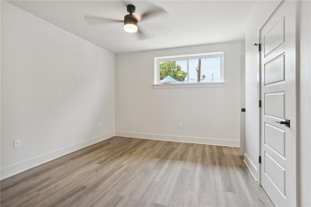 empty room with ceiling fan and light hardwood / wood-style flooring