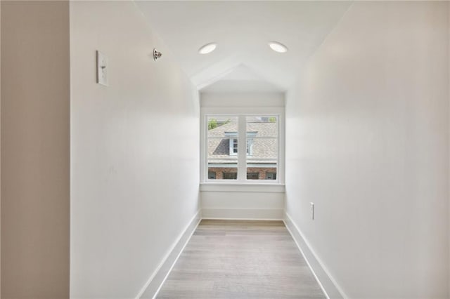 corridor featuring vaulted ceiling and light hardwood / wood-style floors