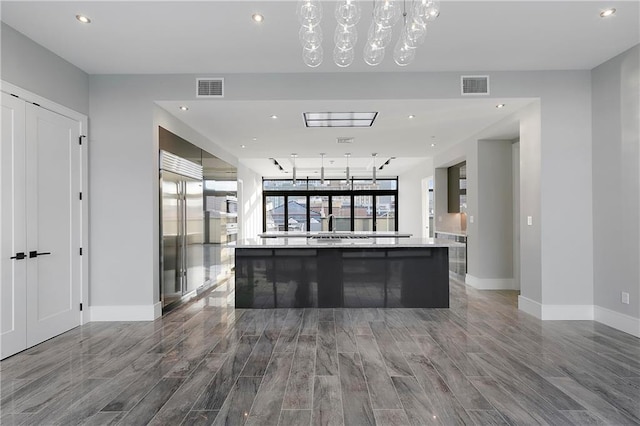 kitchen with built in refrigerator and a large island