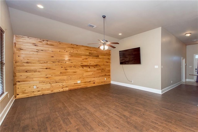 unfurnished room featuring wooden walls, ceiling fan, and dark hardwood / wood-style floors