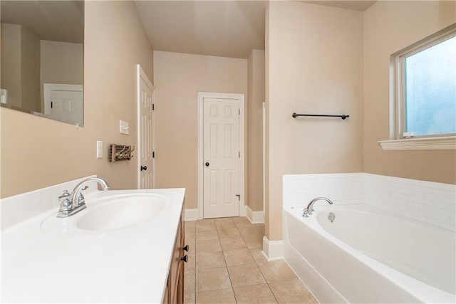 bathroom featuring tile patterned flooring, vanity, and a washtub