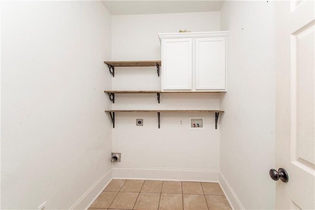 laundry room with electric dryer hookup, hookup for a washing machine, light tile patterned floors, and cabinets