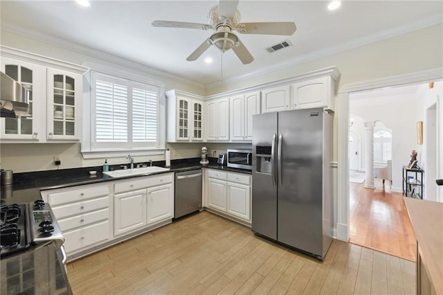 kitchen with sink, stainless steel appliances, crown molding, light hardwood / wood-style floors, and white cabinets