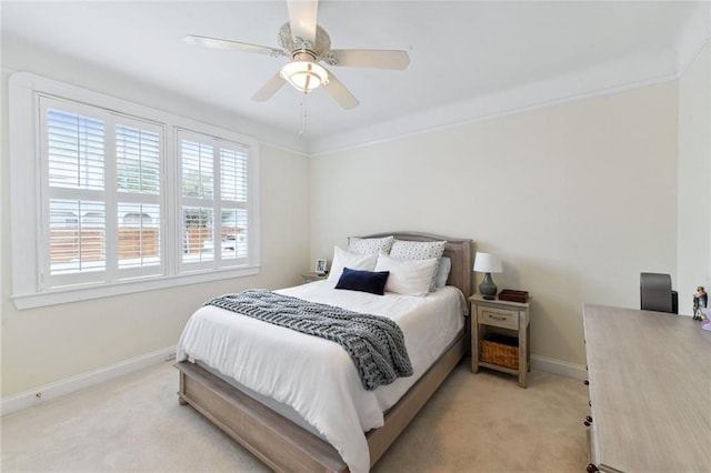 bedroom featuring ceiling fan, crown molding, and light colored carpet