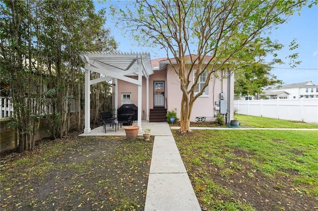 view of front facade with a pergola, a patio, and a front yard