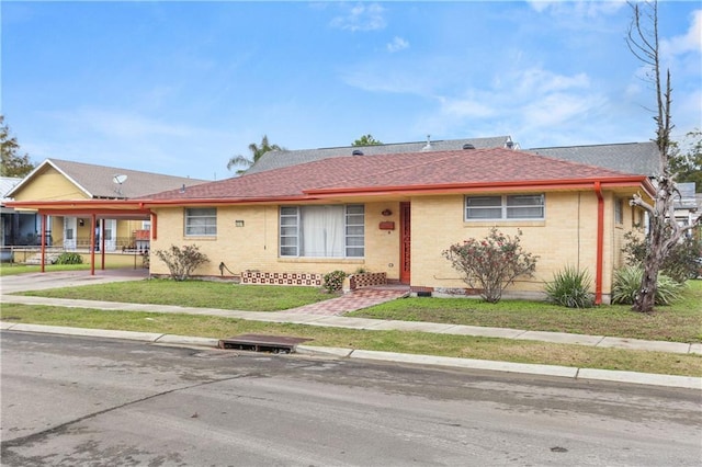 6301 S Rocheblave St, New Orleans, LA 70125 - single story home with brick siding, a front yard, an attached carport, and a shingled roof